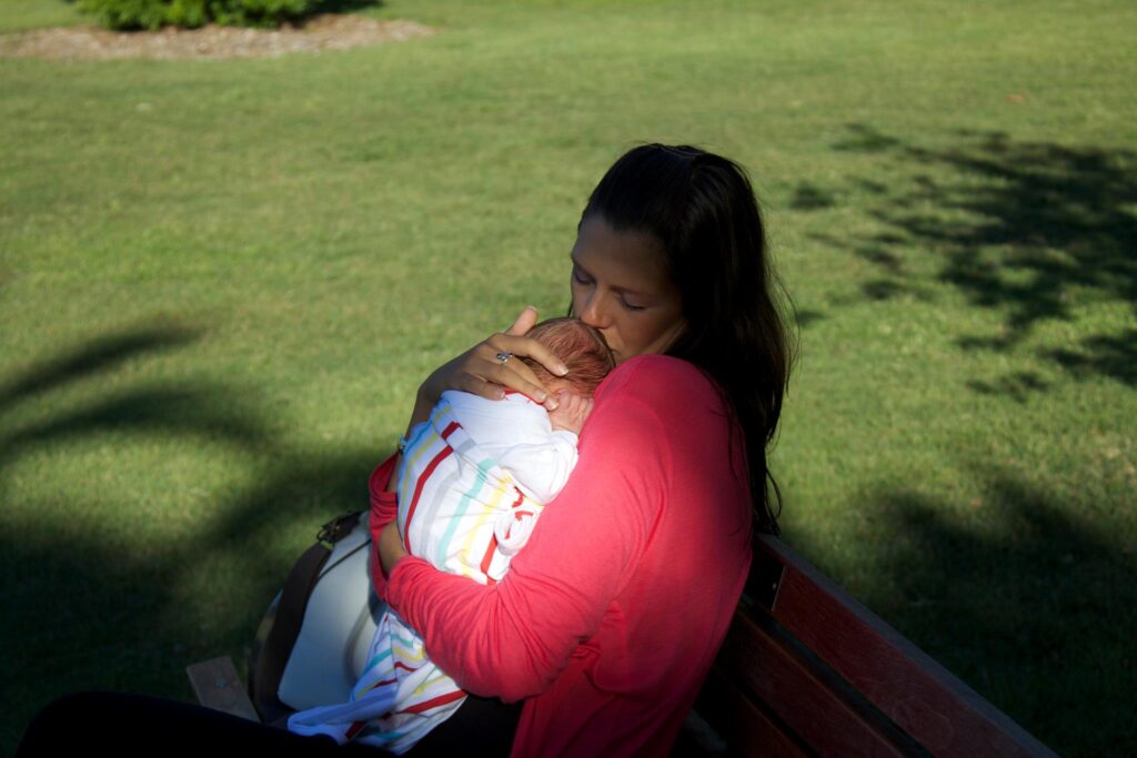 women kissing newborn baby